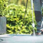 Patio Pressure Cleaning. Caucasian Men Washing His Concrete Floor Patio Using High Pressured Water Cleaner.